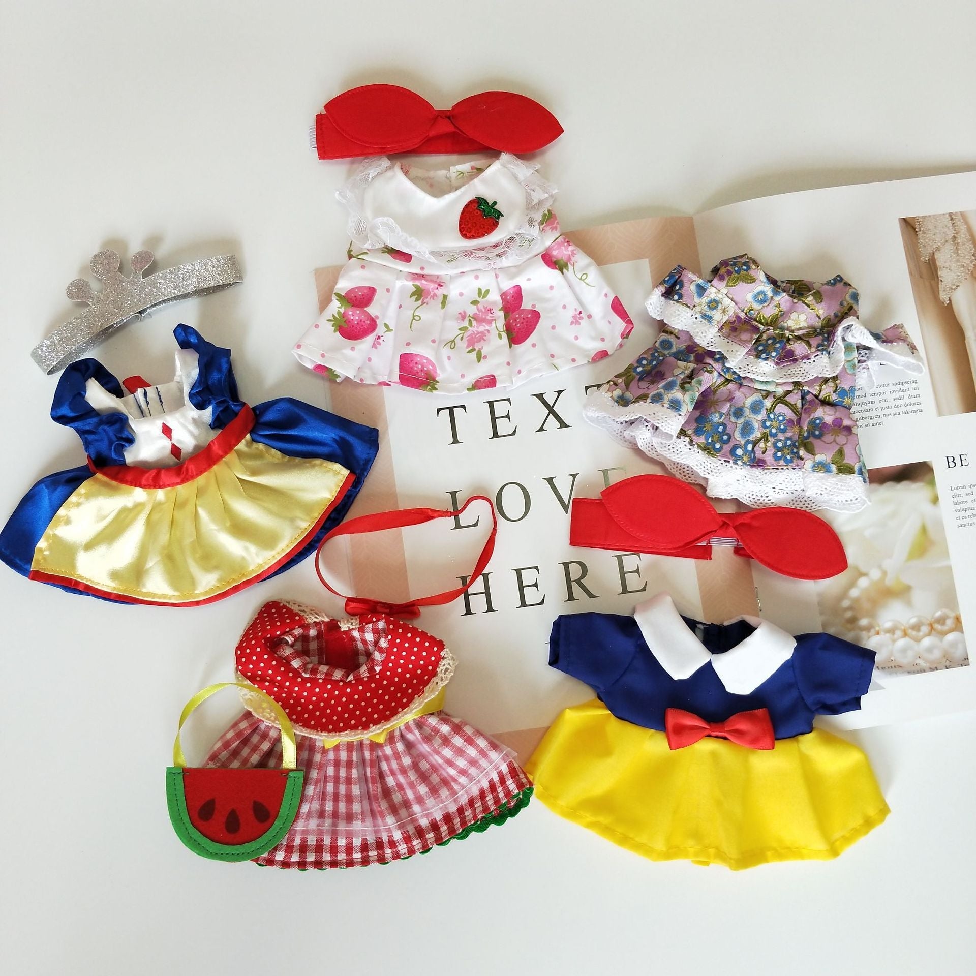 A variety of colorful pet costumes displayed on a table, showcasing different styles and sizes for dogs and cats.