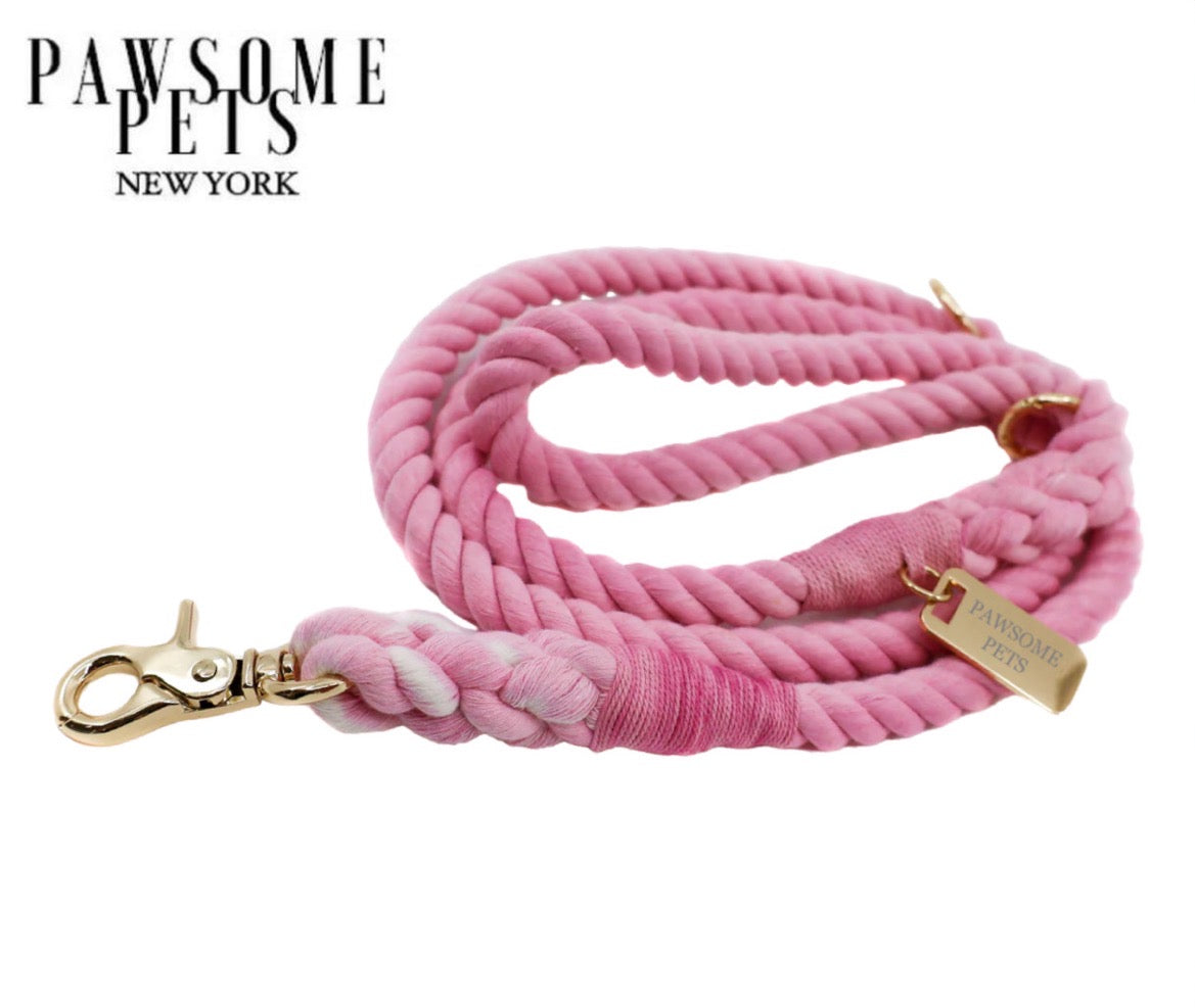 A vibrant pink rope leash with luxe hardware and a matching dog charm, showcasing its durable cotton construction.
