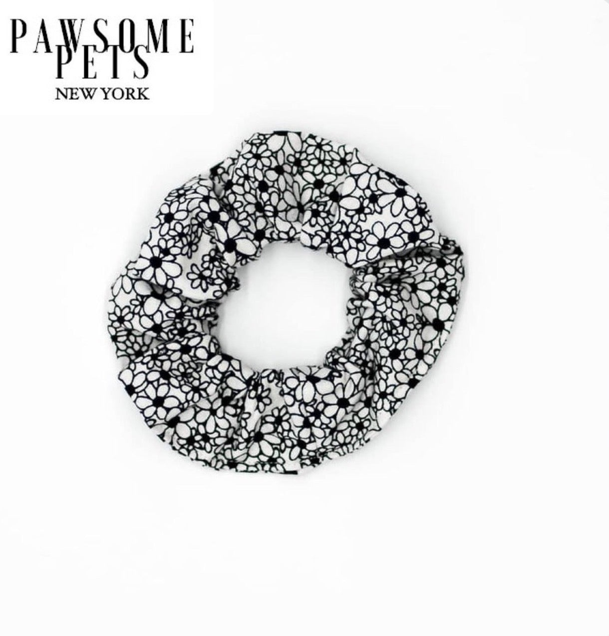 A set of black and white floral scrunchies made from organic cotton, showcasing their stylish design and quality craftsmanship.