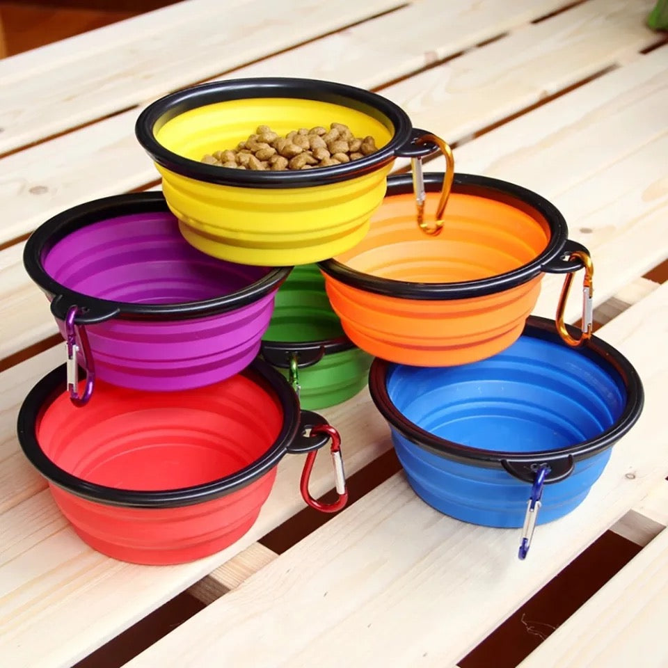 Silicone dog feeder bowl in vibrant color, featuring a carabiner for easy attachment, ideal for travel and outdoor use.