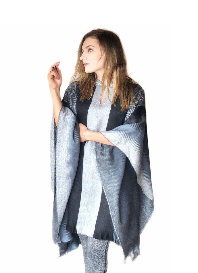 A soft blues and grays alpaca poncho draped elegantly, showcasing its luxurious texture and calming colors.