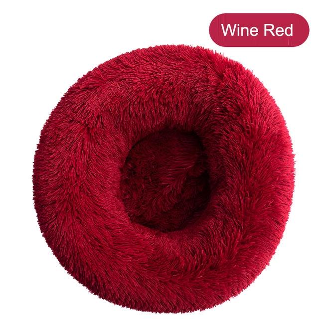 A soft, round dog bed made of plush coral fleece, designed for winter comfort, suitable for small and large dogs and cats.