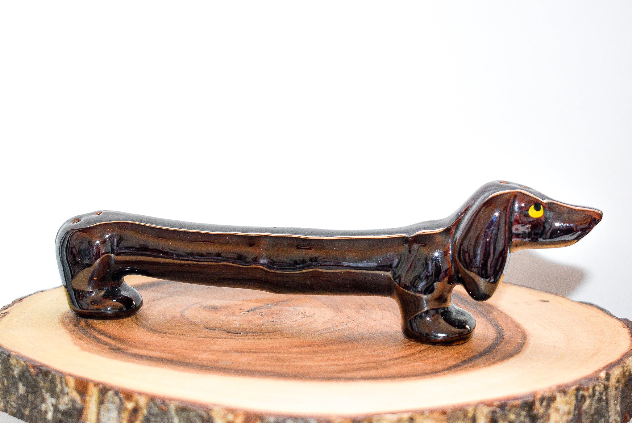 A beautifully crafted vintage porcelain dachshund figurine, measuring approximately 8 x 3 inches, showcasing intricate details and a charming design.