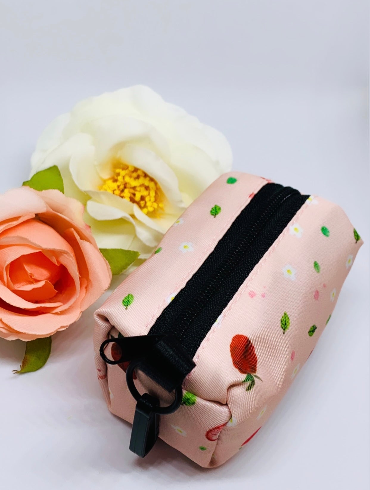 Stylish strawberry-themed waste bag holder made of heavyweight neoprene, featuring a black clasp and compact design.