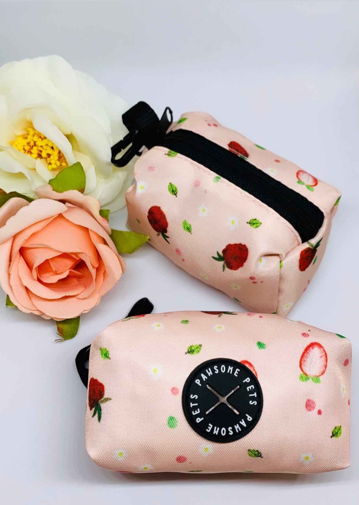 Stylish strawberry-themed waste bag holder made of heavyweight neoprene, featuring a black clasp and compact design.