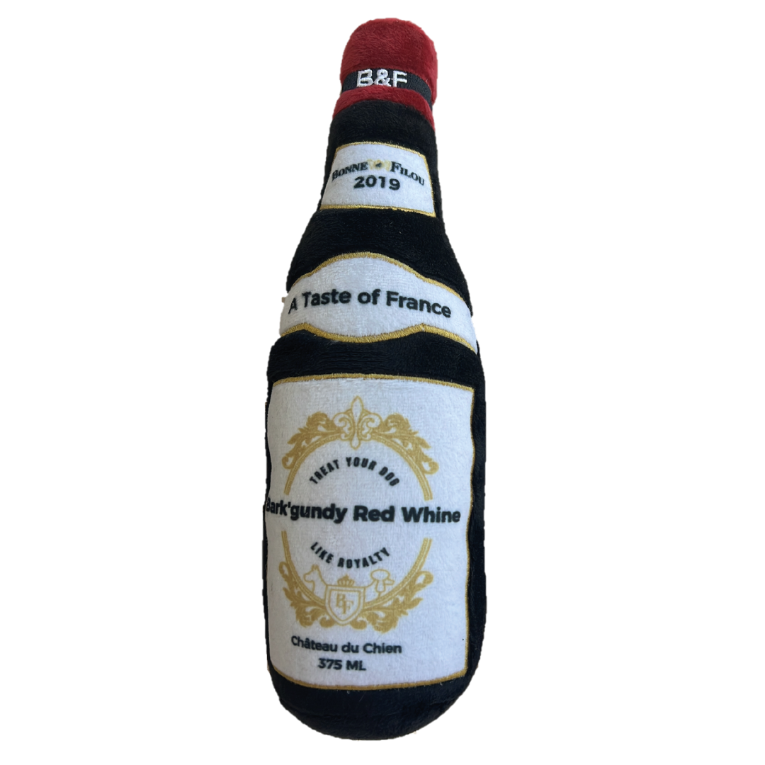 A plush dog toy shaped like a wine bottle in Bark'gundy color, featuring a squeaker and made from soft recycled materials.