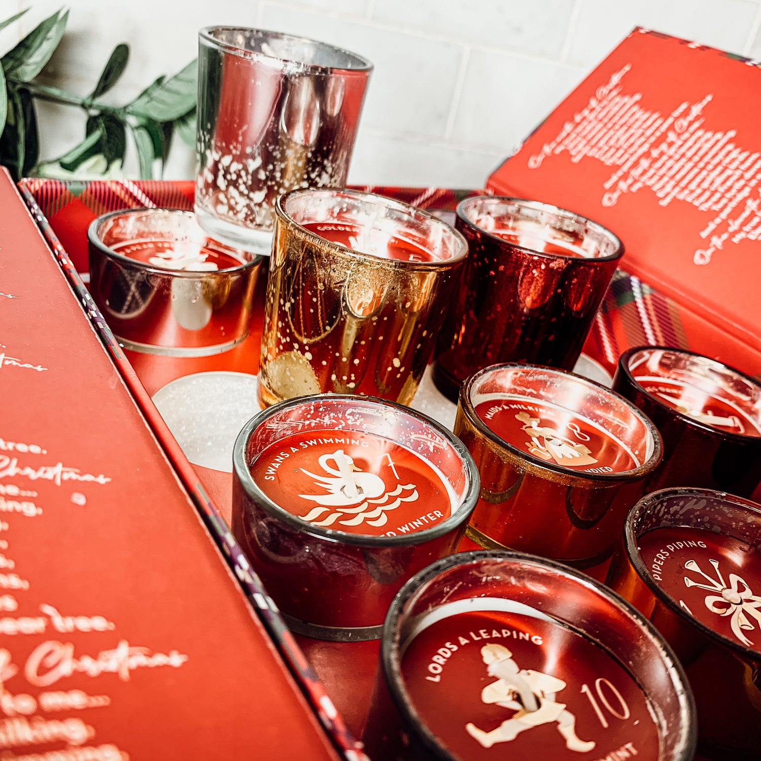 Advent Candle Set featuring 12 scented candles in a festive gift box with Silver, Gold, and Red colors.