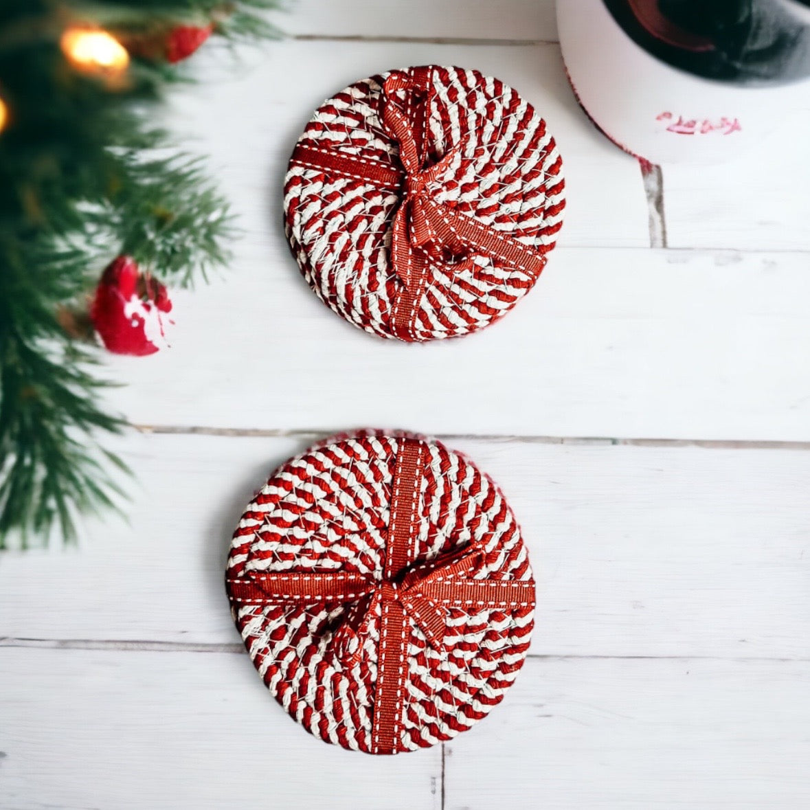 A set of four candy cane striped coasters with braided detail, perfect for holiday decor.