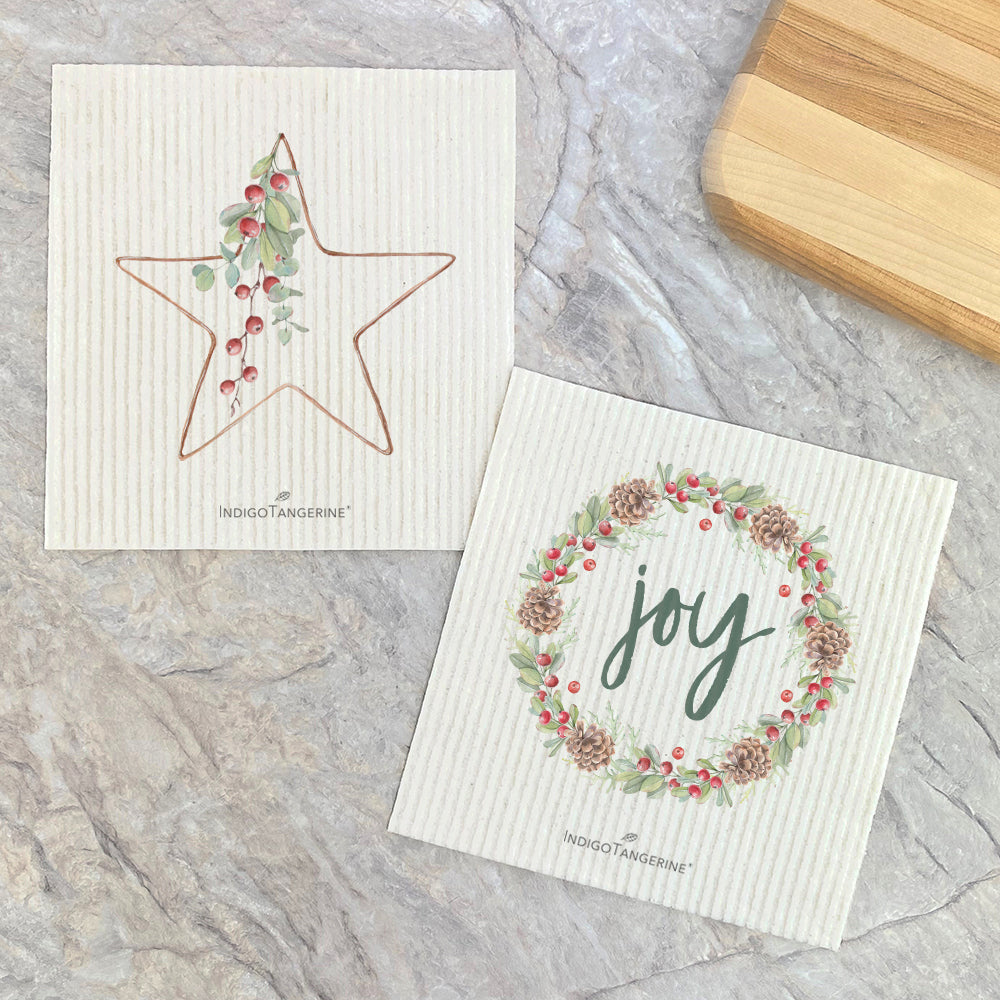 Two Swedish dishcloths featuring Christmas Star and Joy Wreath designs, made from eco-friendly materials.
