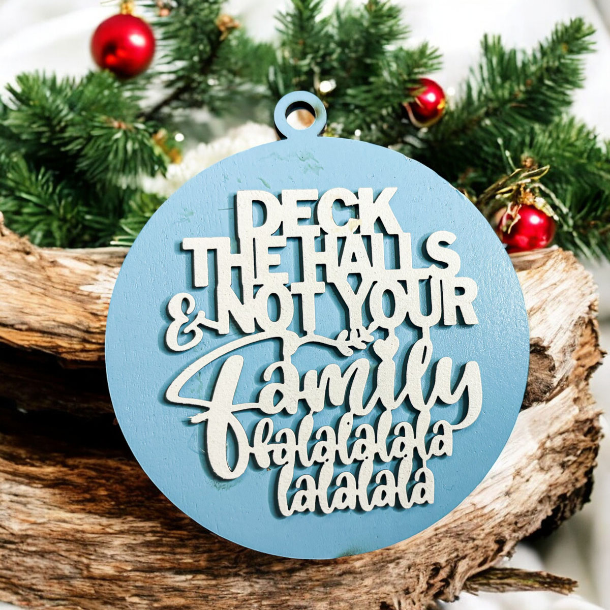 Colorful wooden ornament with the phrase 'Deck the Halls (and Not Your Family)', featuring a 3D design and rustic twine for hanging.