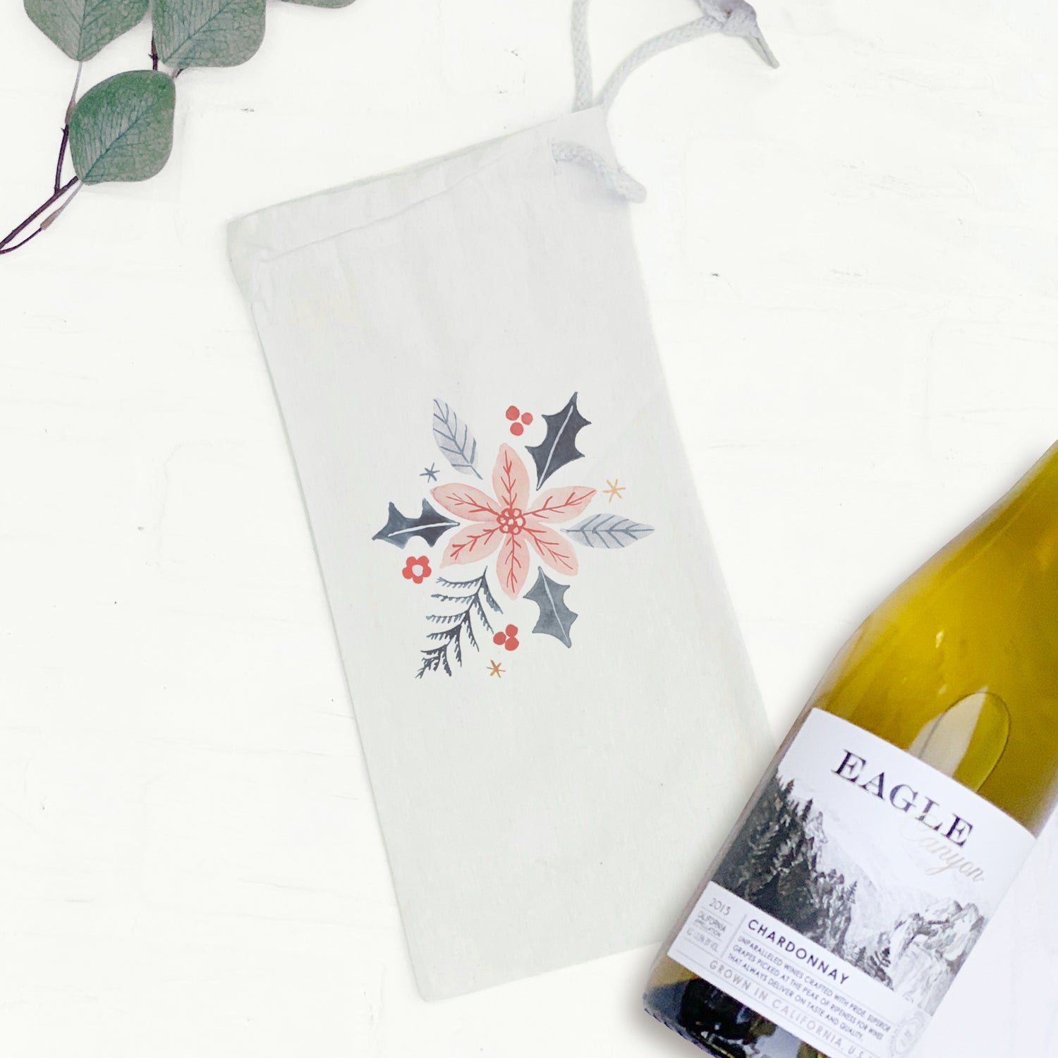 Hand drawn pink poinsettia design on a durable canvas wine bag, featuring a matching drawstring closure.