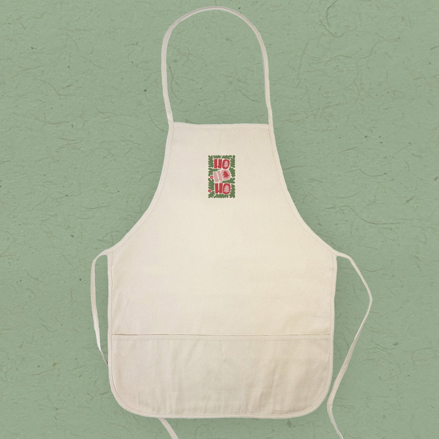 Ho Ho Ho Women's Apron featuring festive design, adjustable neck strap, and divided front pocket, made from durable cotton canvas.