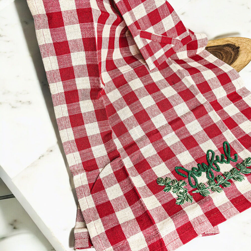 Holiday Charcuterie & Tartan Towel Set featuring a wooden charcuterie board and a tartan print kitchen towel in red and green.