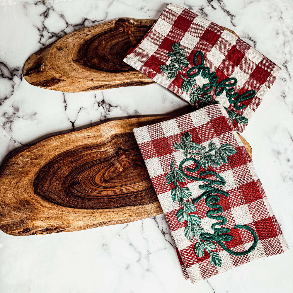 Holiday Charcuterie & Tartan Towel Set featuring a wooden charcuterie board and a tartan print kitchen towel in red and green.