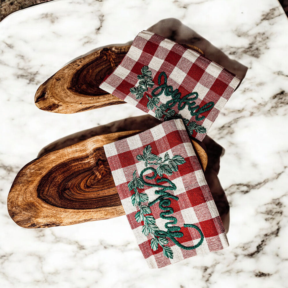 Holiday Charcuterie & Tartan Towel Set featuring a wooden charcuterie board and a tartan print kitchen towel in red and green.