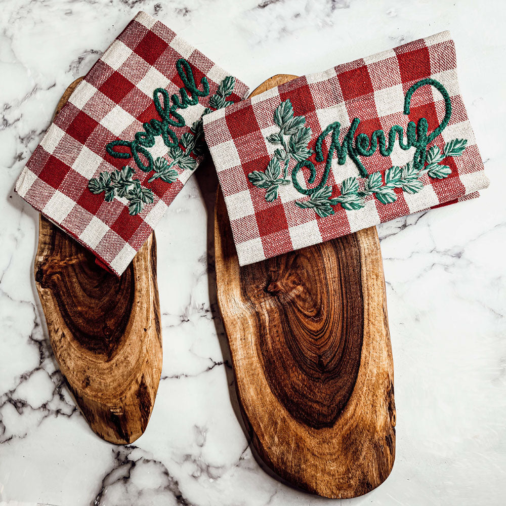 Holiday Charcuterie & Tartan Towel Set featuring a wooden charcuterie board and a tartan print kitchen towel in red and green.