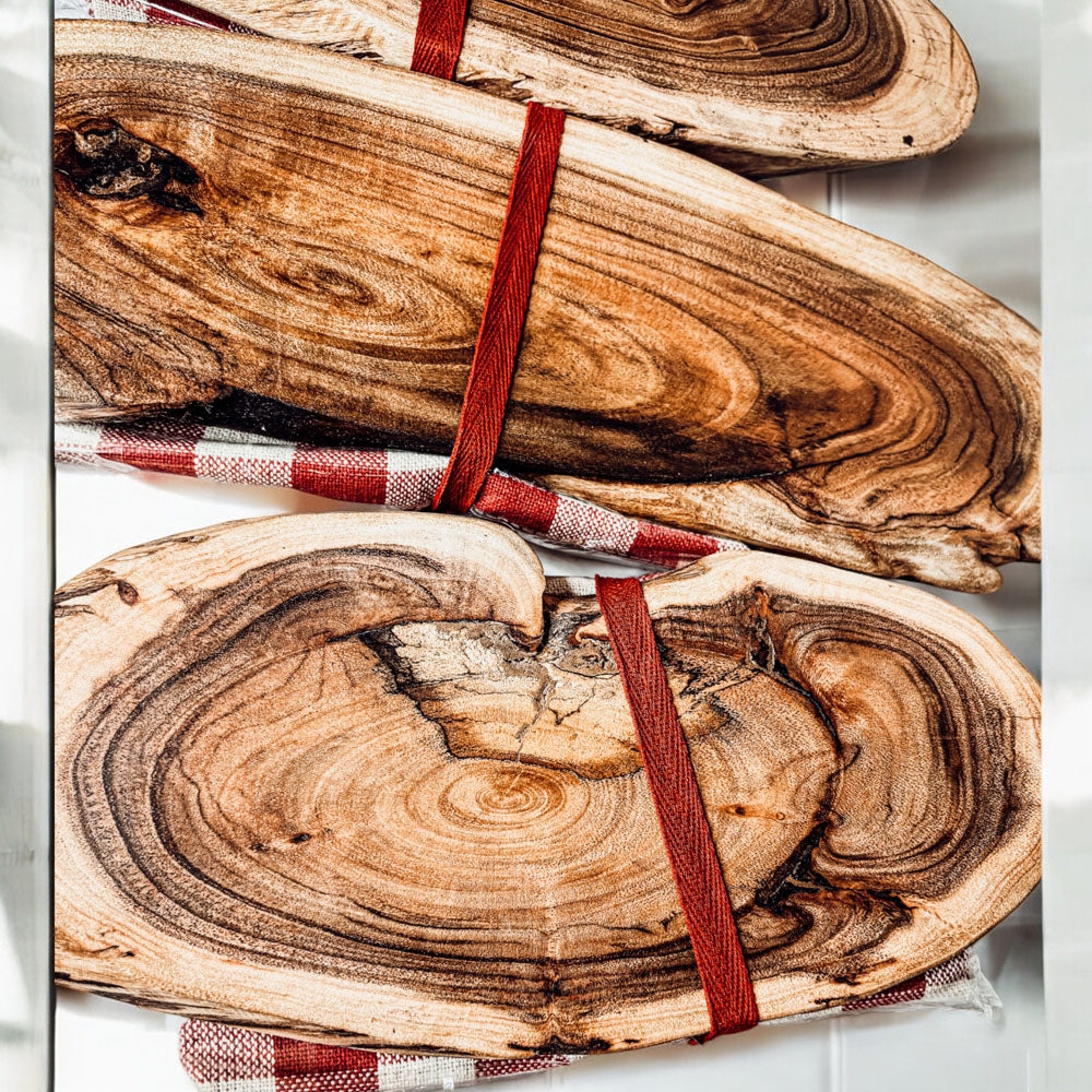 Holiday Charcuterie & Tartan Towel Set featuring a wooden charcuterie board and a tartan print kitchen towel in red and green.