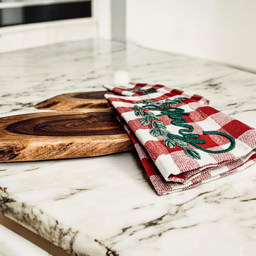 Holiday Charcuterie & Tartan Towel Set featuring a wooden charcuterie board and a tartan print kitchen towel in red and green.
