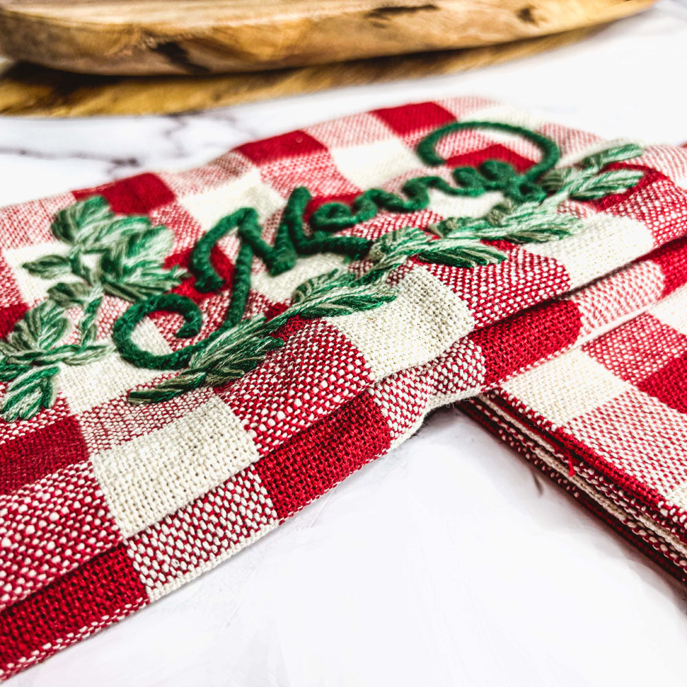 Holiday Charcuterie & Tartan Towel Set featuring a wooden charcuterie board and a tartan print kitchen towel in red and green.