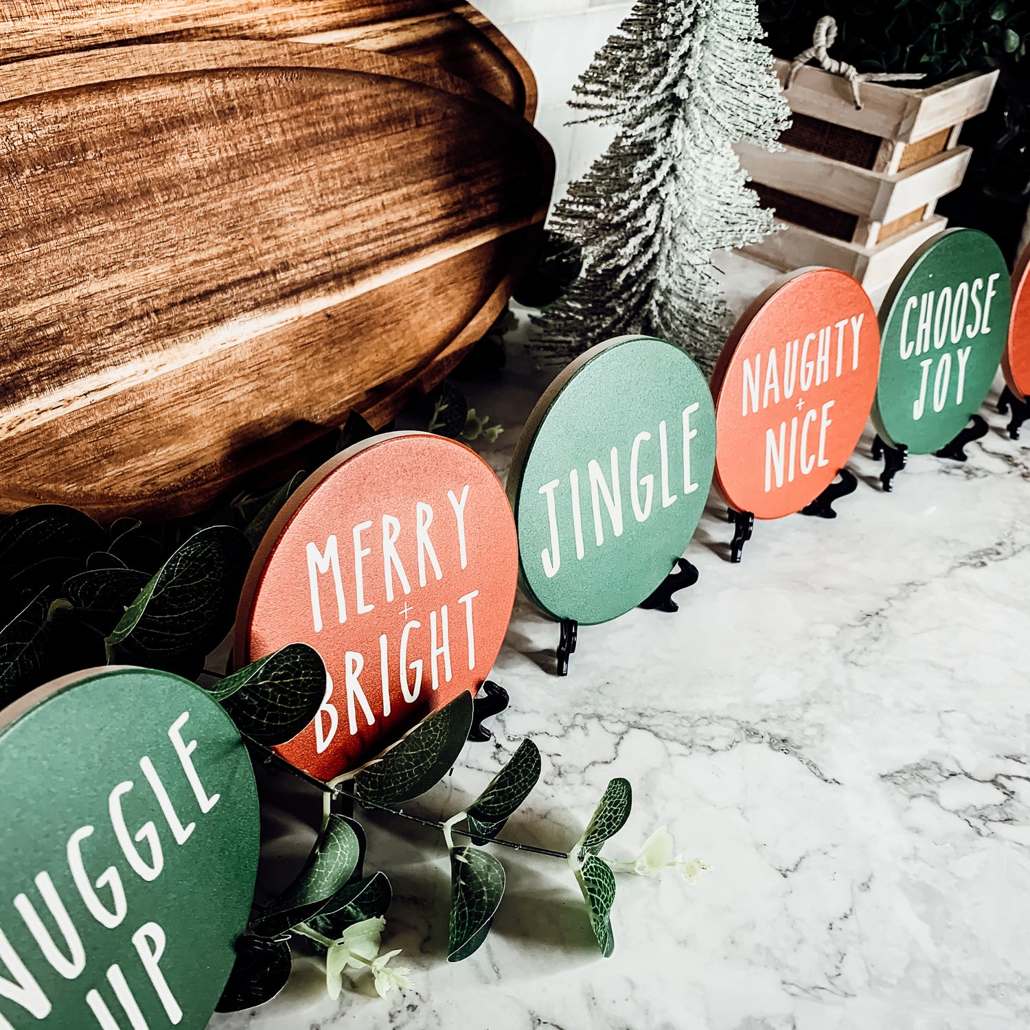 Set of six premium ceramic coasters with cork backing, featuring festive holiday designs including 'Choose Joy' and 'Merry + Bright'.