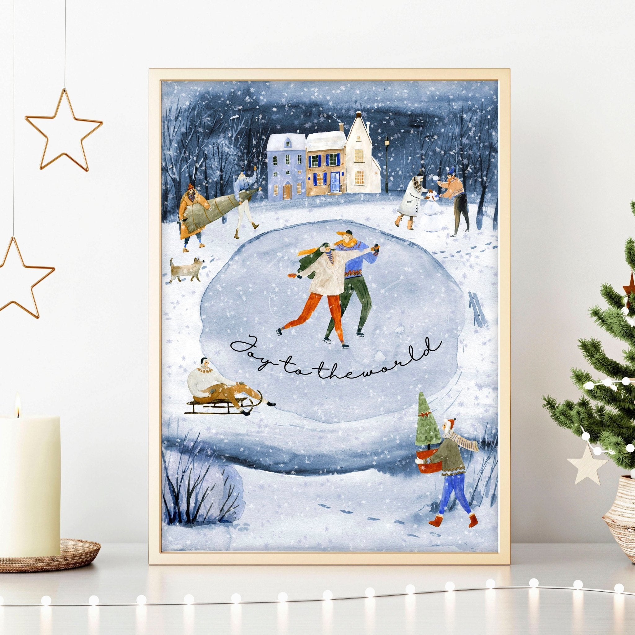 A beautiful indoor Christmas wall art print featuring a serene blue watercolour landscape with a snowy pond and a charming village adorned with lights.