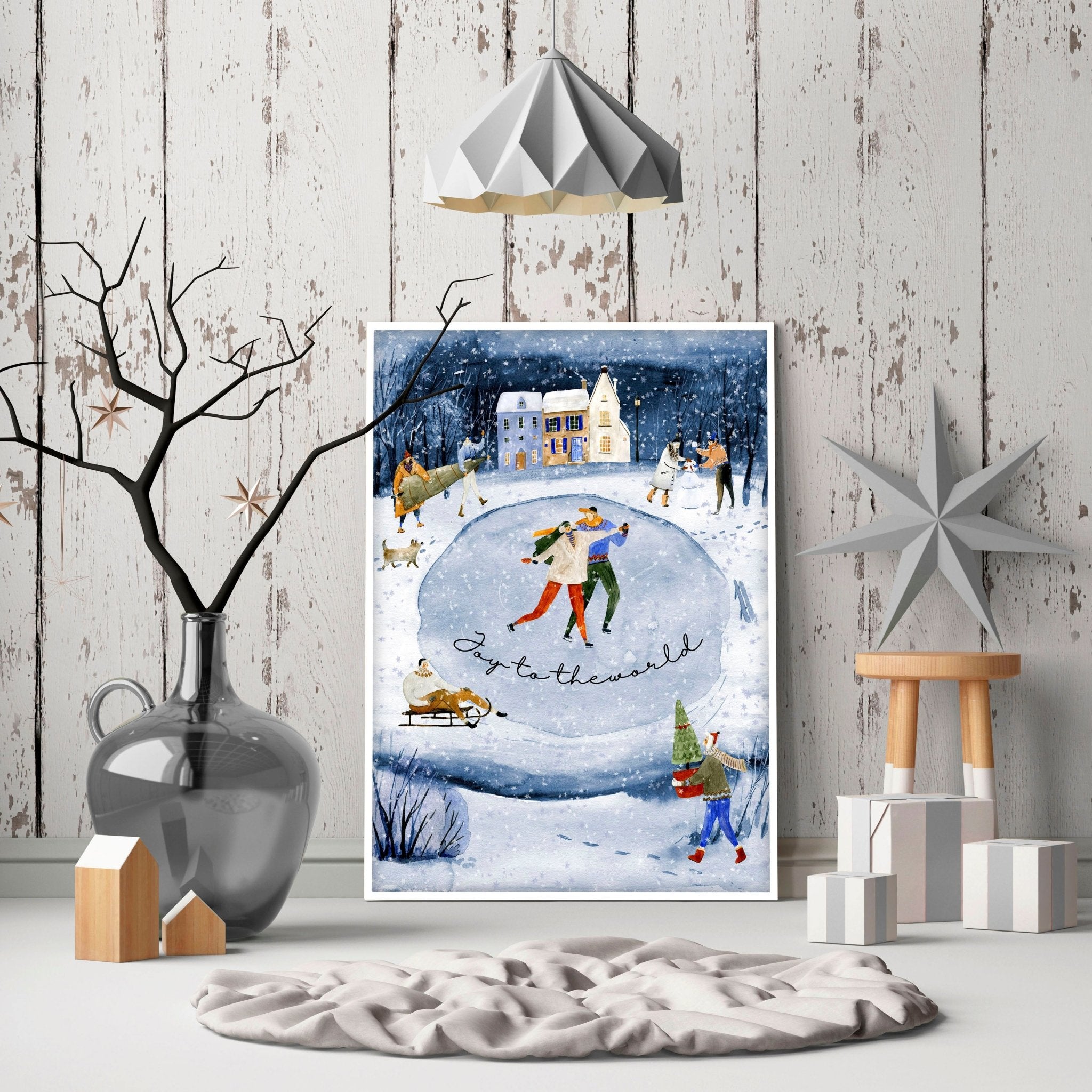 A beautiful indoor Christmas wall art print featuring a serene blue watercolour landscape with a snowy pond and a charming village adorned with lights.