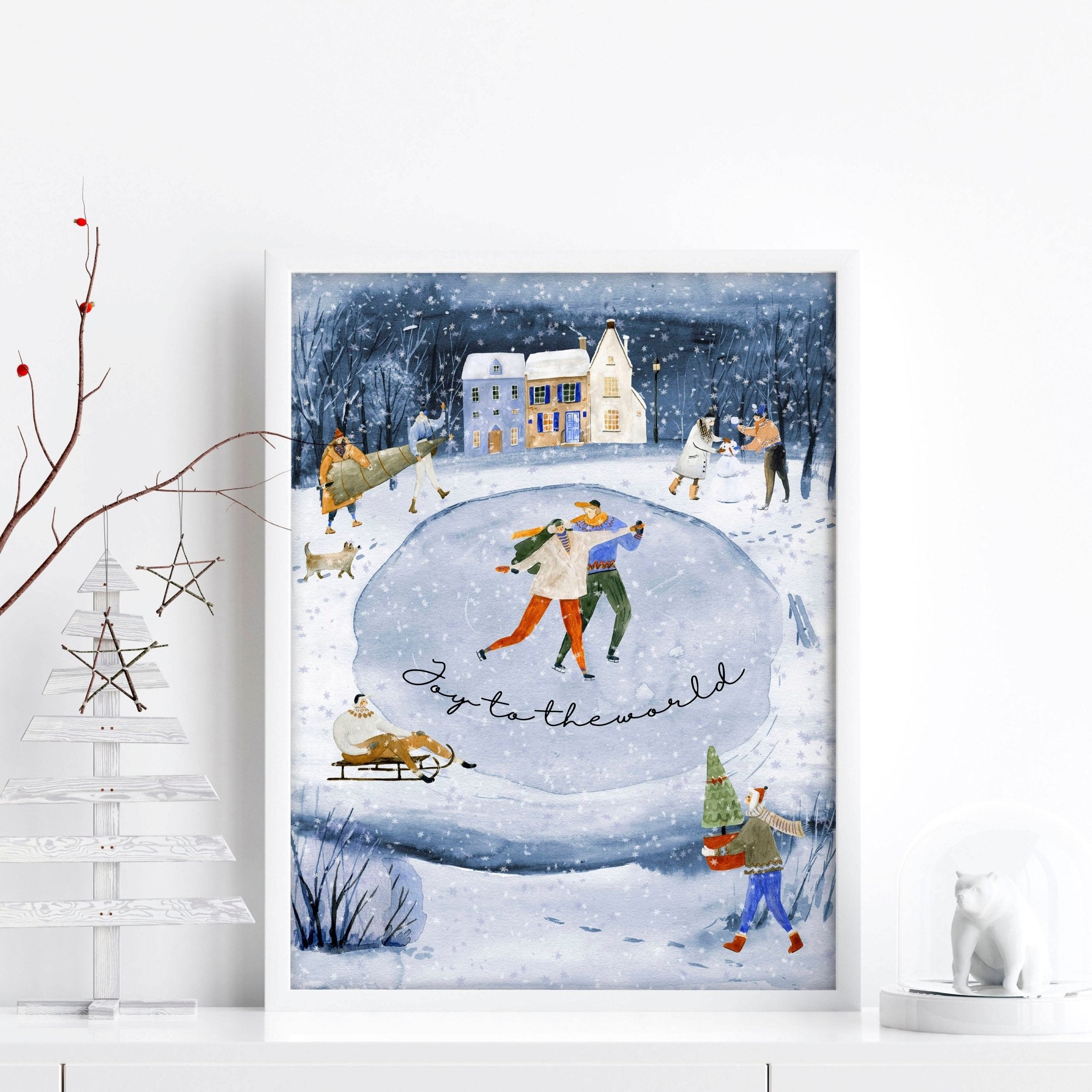A beautiful indoor Christmas wall art print featuring a serene blue watercolour landscape with a snowy pond and a charming village adorned with lights.
