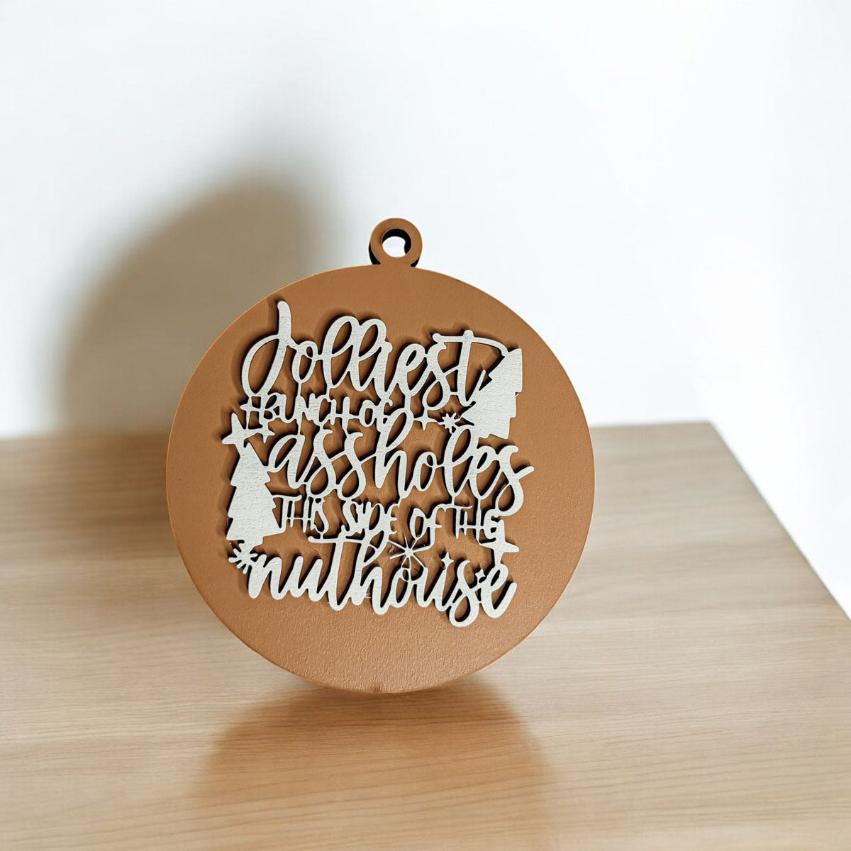 Jolliest Bunch Wooden Ornament featuring festive graphics and rustic twine, available in 12 vibrant colors.