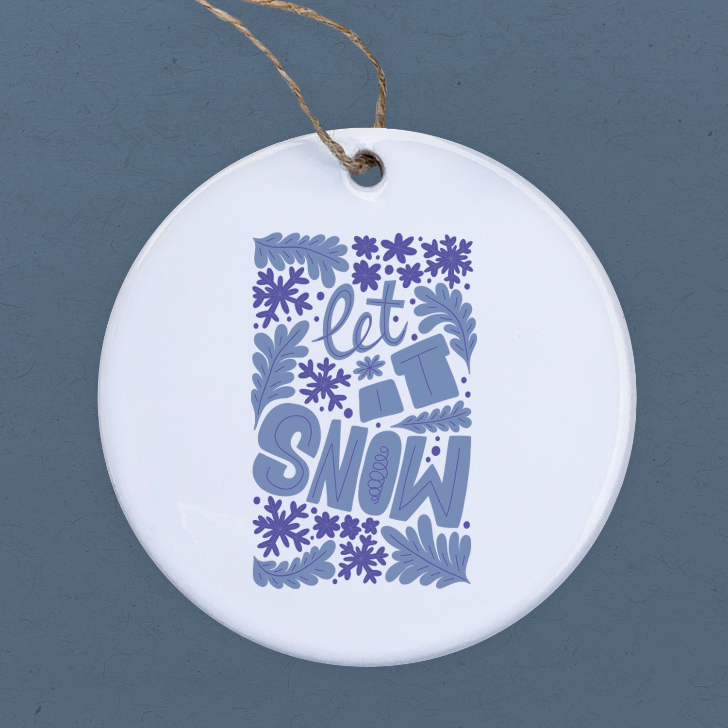 Let it Snow porcelain ornament featuring original design, 2.75 inches in diameter, with a smooth glossy finish.