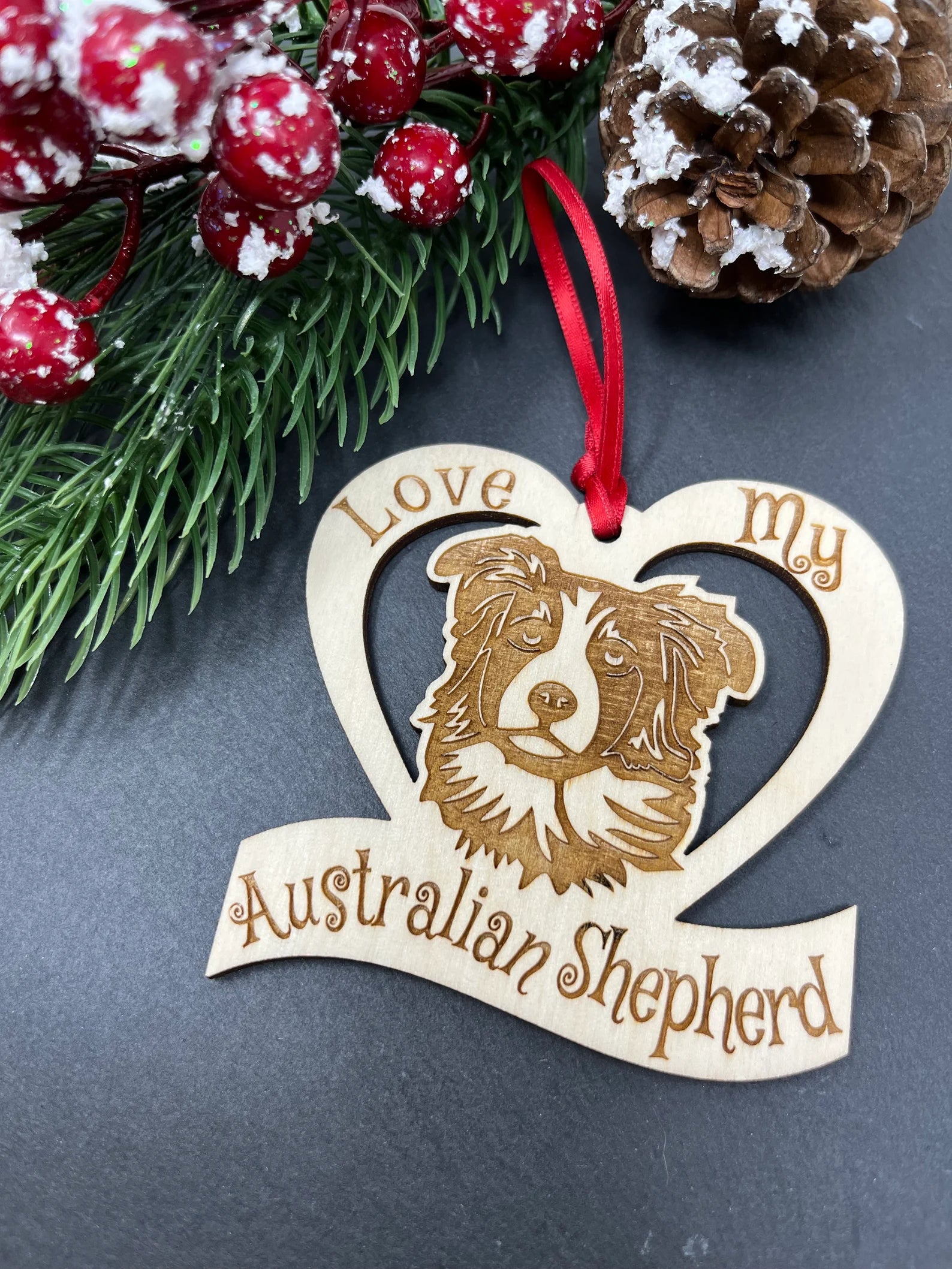 Laser engraved wooden ornament featuring an Australian Shepherd design, perfect for Christmas decoration.