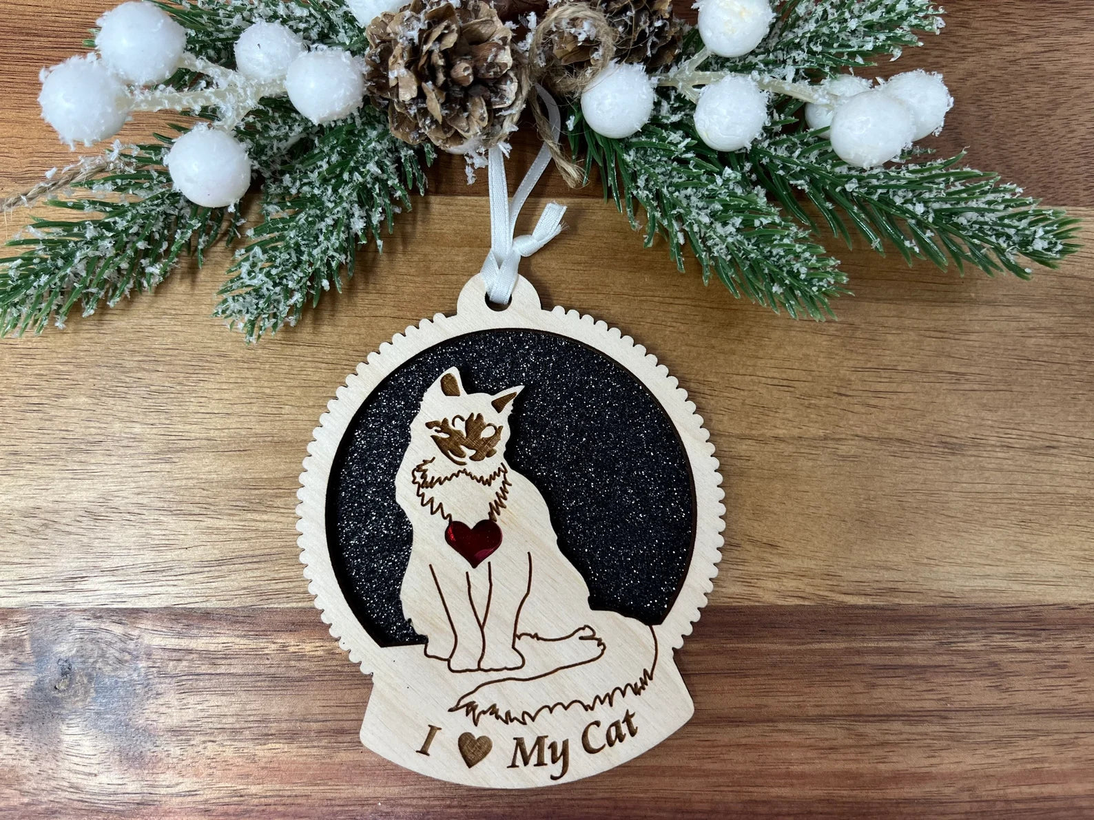 A beautifully crafted laser-cut wooden ornament featuring a cat silhouette, perfect for Christmas decoration.