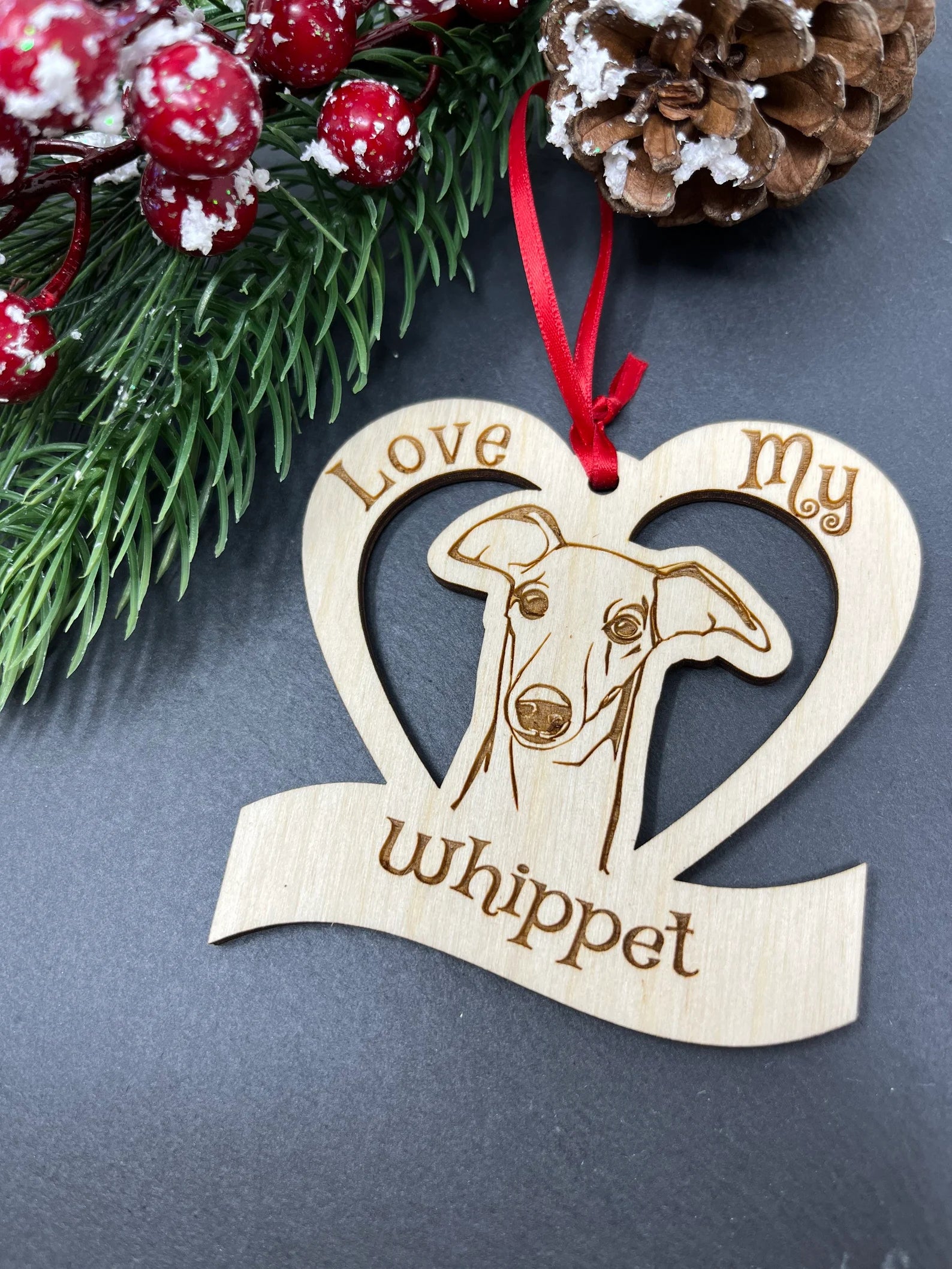 Love My Whippet ornament made of laser engraved Baltic Birch wood, featuring a unique design and attached ribbon for hanging.