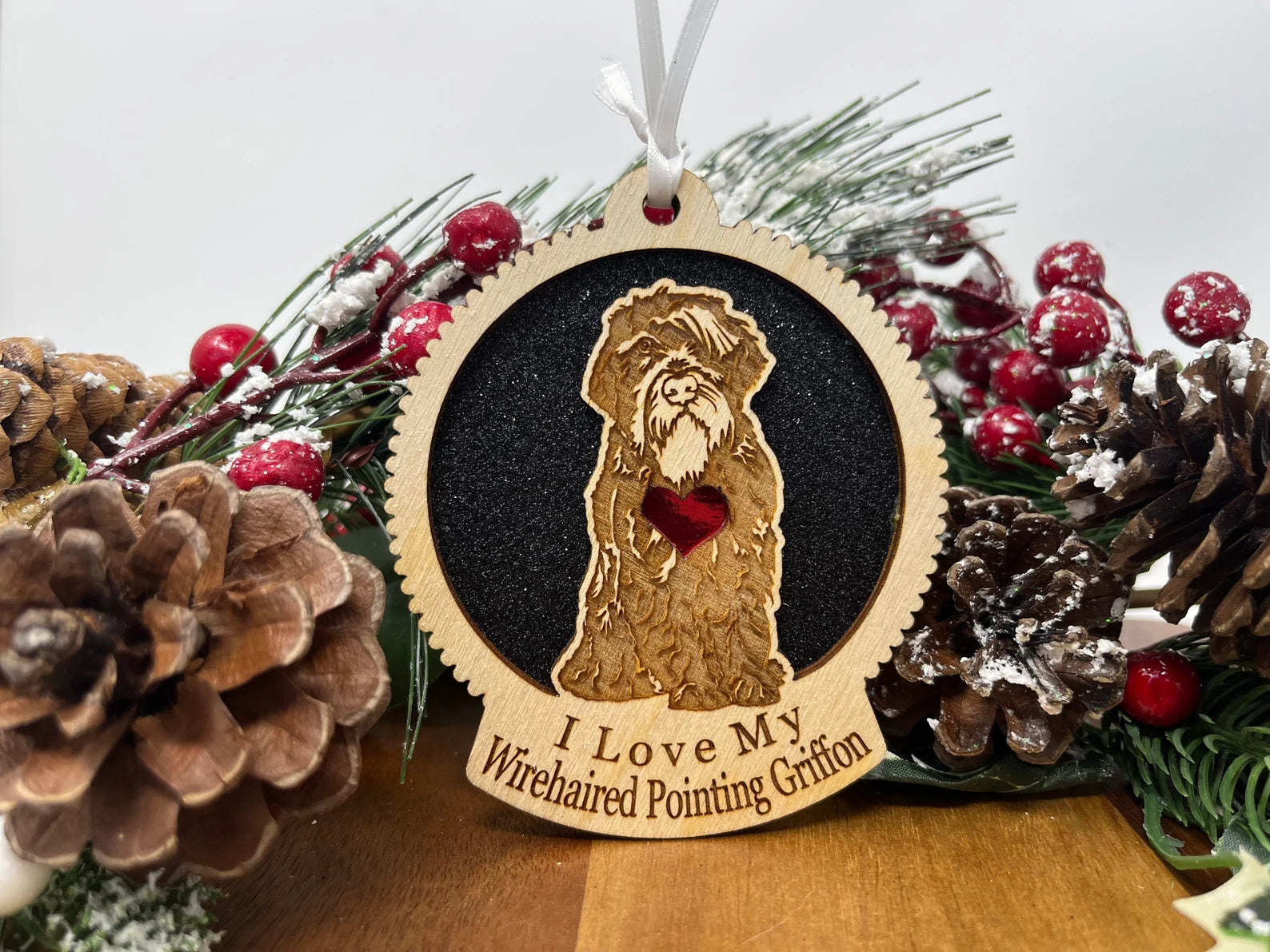 A beautifully crafted wooden ornament featuring a silhouette of a Wirehaired Pointing Griffon, perfect for Christmas decoration.