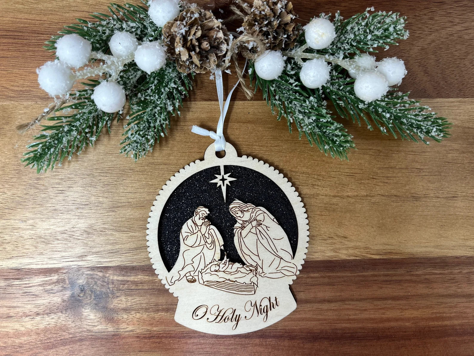 O Holy Night nativity ornament made from birch wood, featuring intricate cut designs and a decorative ribbon, perfect for Christmas trees.