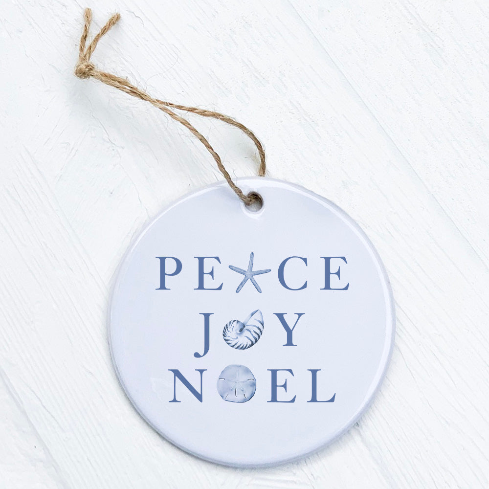 A beautifully crafted porcelain ornament featuring the words 'Peace Joy Noel' with a smooth, glossy finish, perfect for holiday decor.