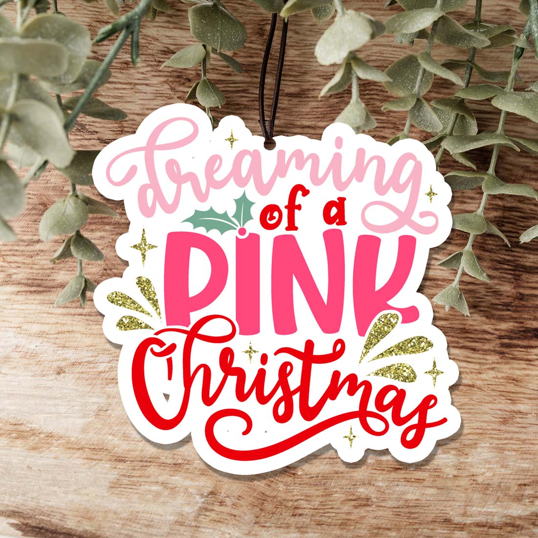 A pink Christmas air freshener shaped like a festive ornament, hanging with a decorative design, perfect for holiday decor.