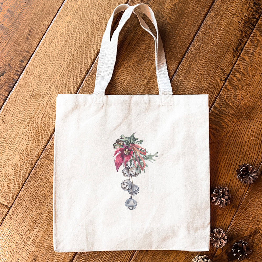 Poinsettia Bells Canvas Tote Bag featuring vibrant floral design, heavy-duty fabric, and reinforced straps.