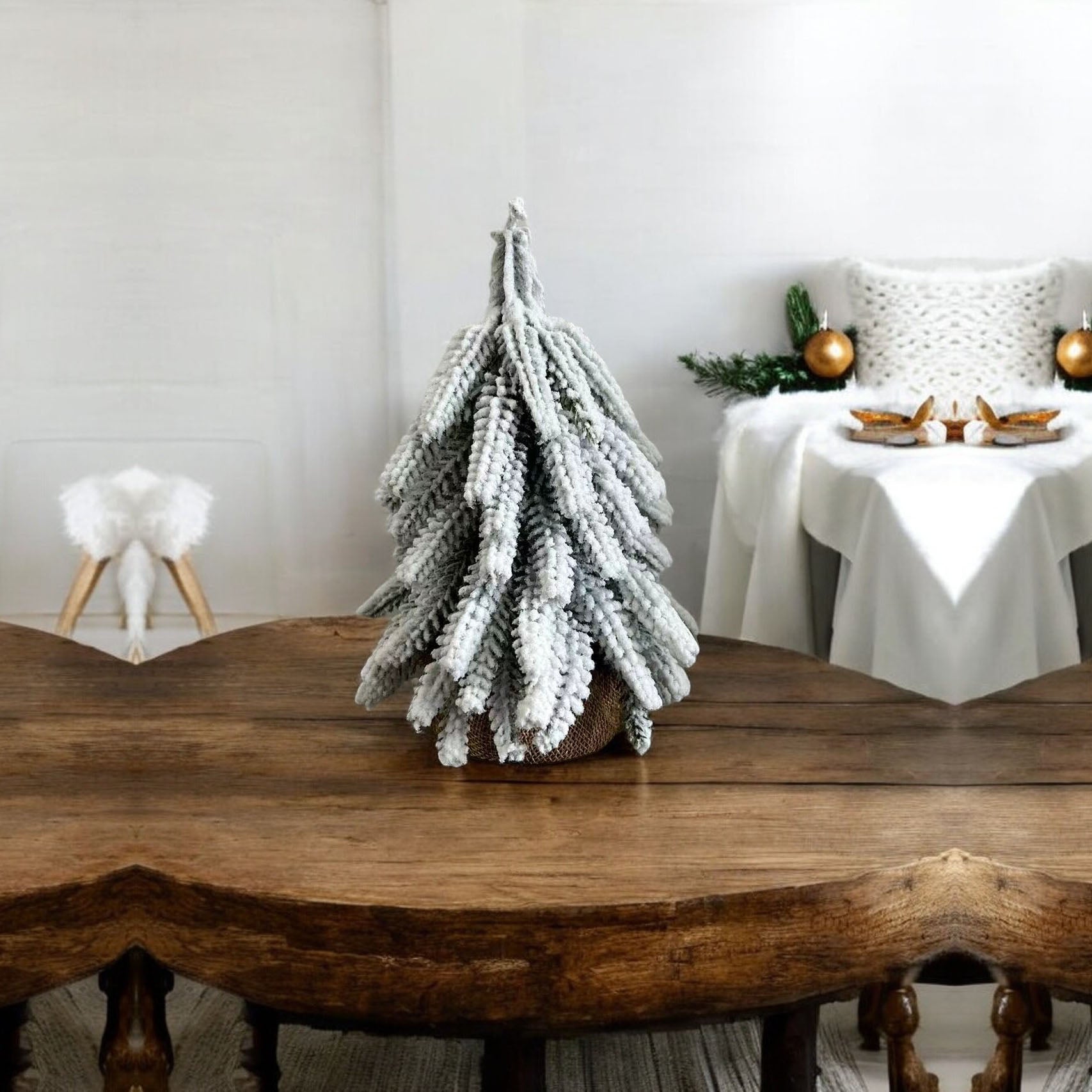 A set of four snow-covered Christmas trees in varying sizes, featuring a jute-covered wooden base, perfect for holiday decor.