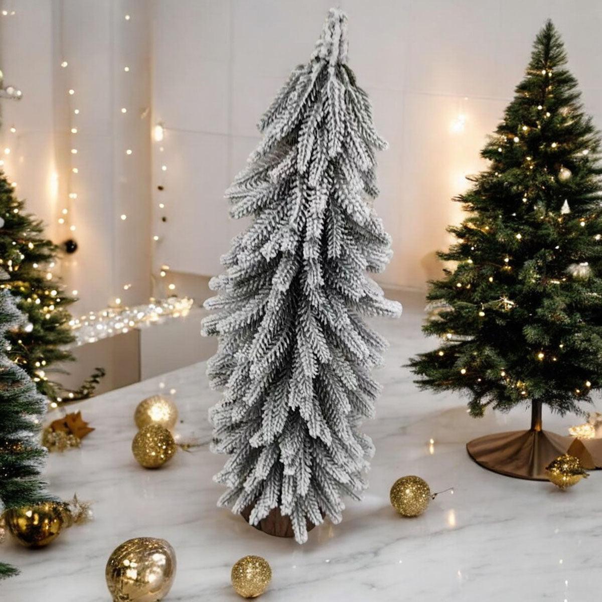 A set of four snow-covered Christmas trees in varying sizes, featuring a jute-covered wooden base, perfect for holiday decor.
