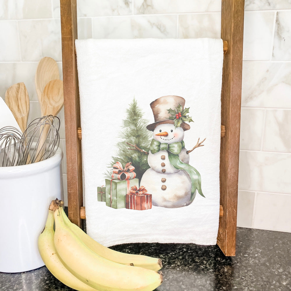 A vibrant cotton tea towel featuring a snowman and presents design, perfect for holiday kitchen decor.