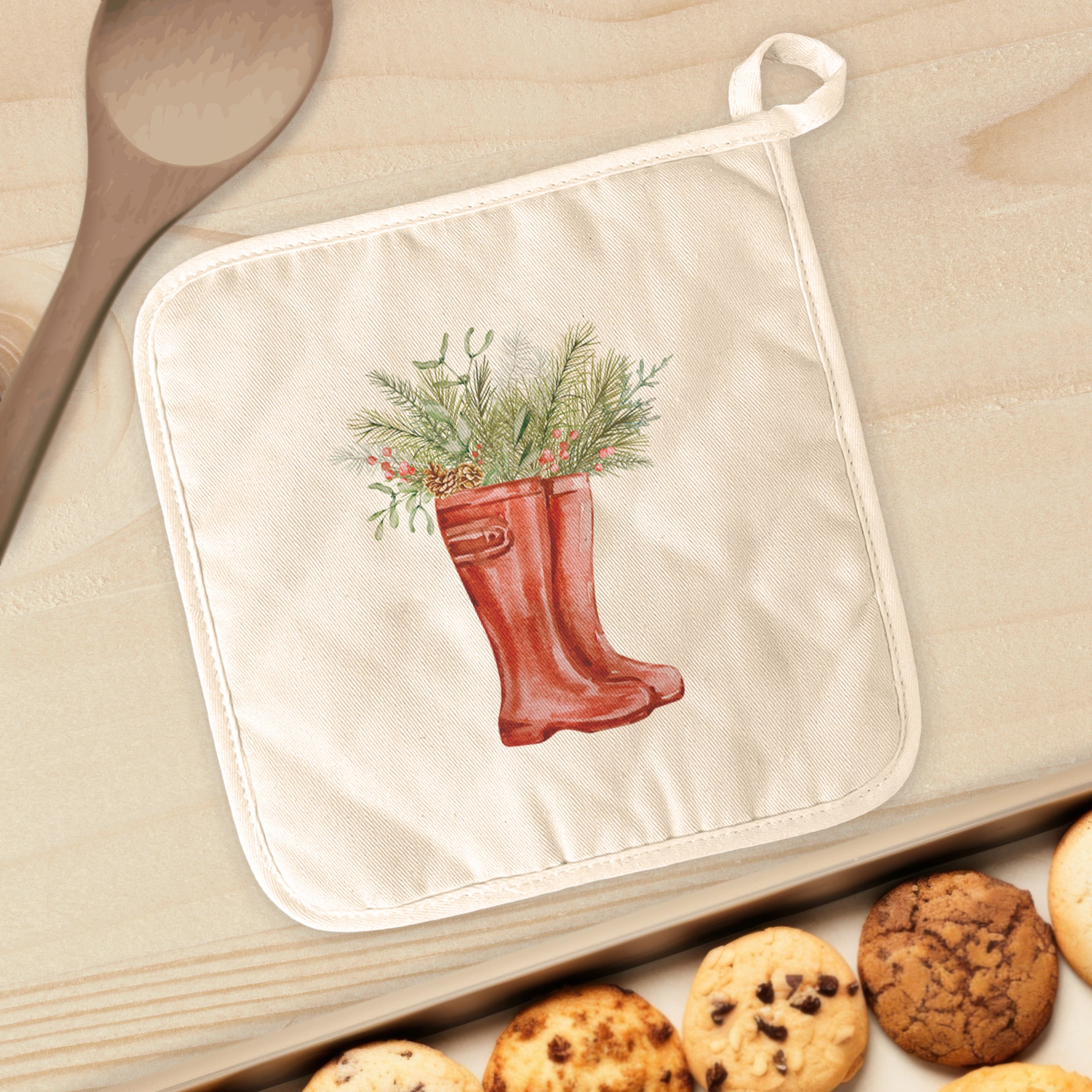 A vibrant cotton pot holder featuring winter rain boots and foliage design, perfect for protecting surfaces from hot cookware.