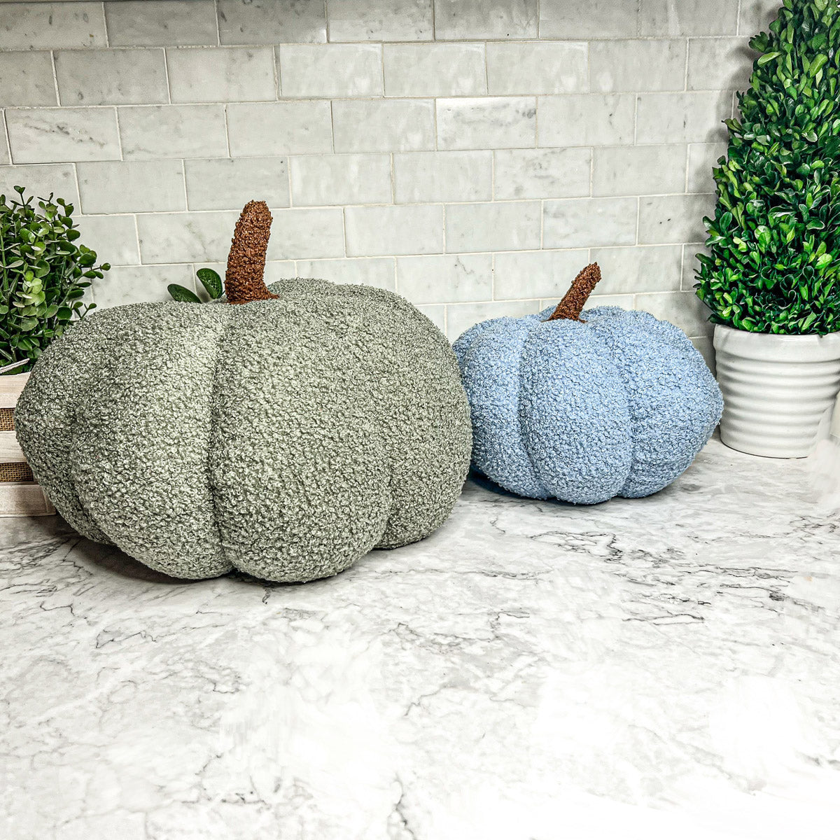 A collection of plush Blair Pumpkins in various colors including blue, gray, and orange, showcasing their soft texture and classic pumpkin shape.