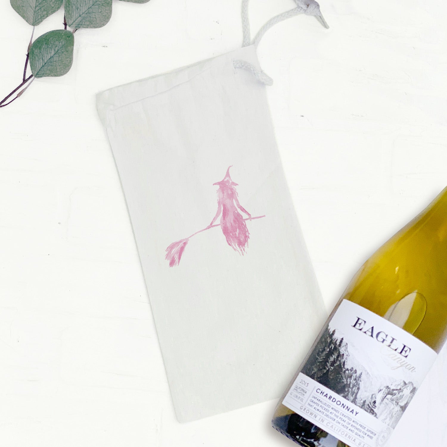 A stylish pink canvas wine bag featuring a whimsical witch silhouette design, perfect for gifting wine on various occasions.