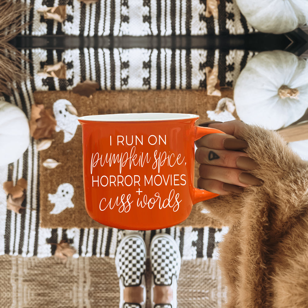 Pumpkin + Horror Mug featuring vibrant orange color and white lettering, perfect for fall and horror movie lovers.