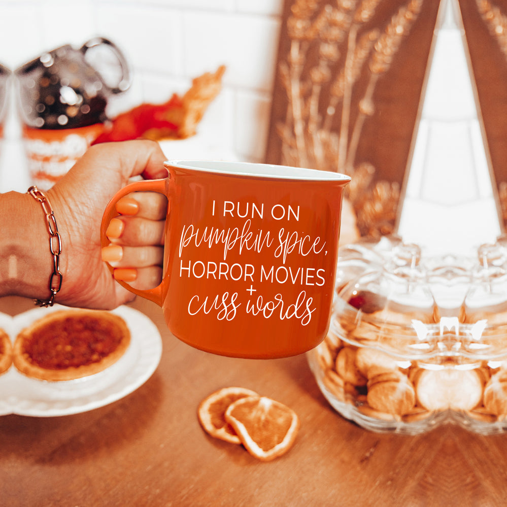 Pumpkin + Horror Mug featuring vibrant orange color and white lettering, perfect for fall and horror movie lovers.