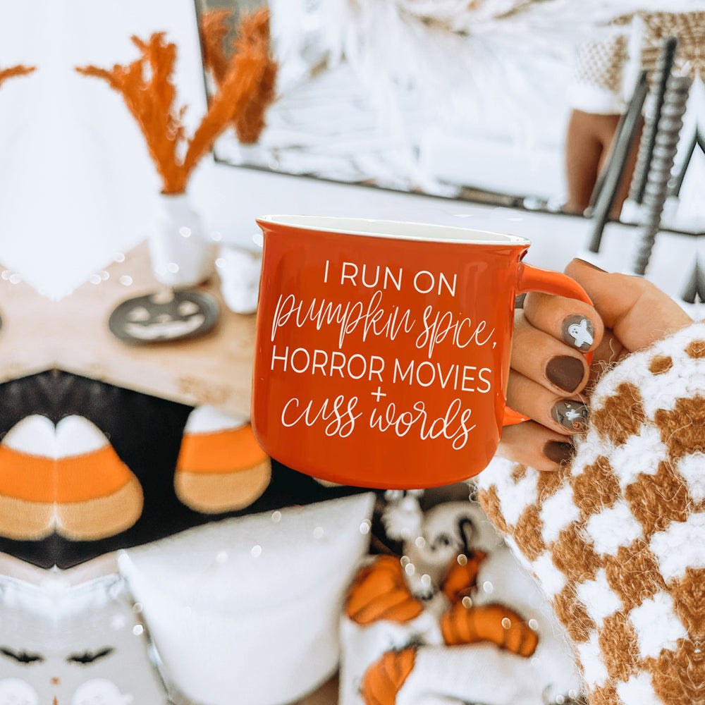 Pumpkin + Horror Mug featuring vibrant orange color and white lettering, perfect for fall and horror movie lovers.