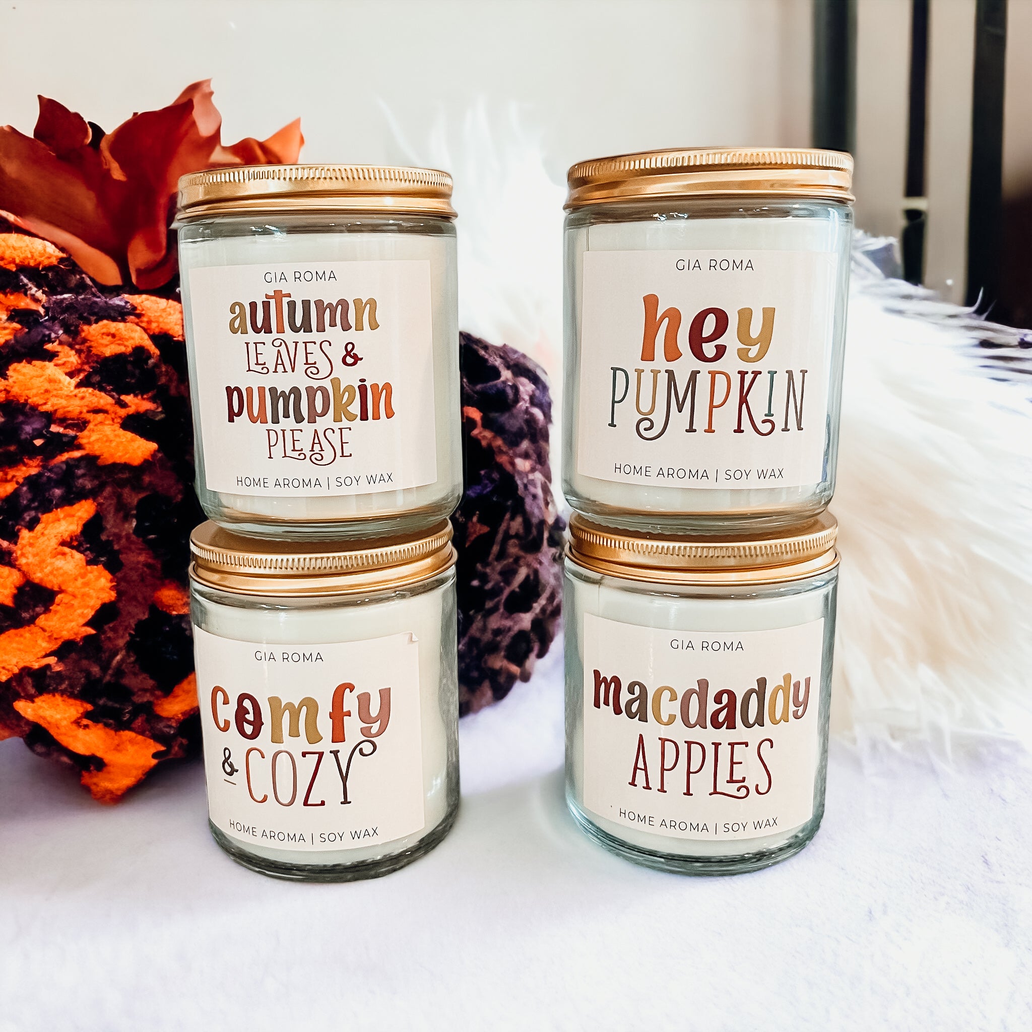 Four autumn-themed scented candles.