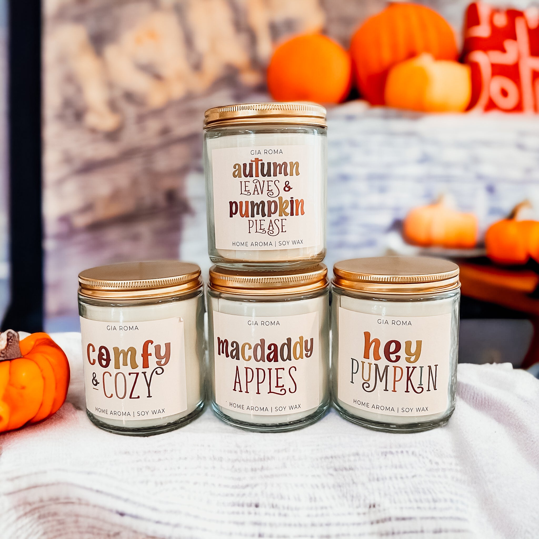 Four autumn-themed scented candles.
