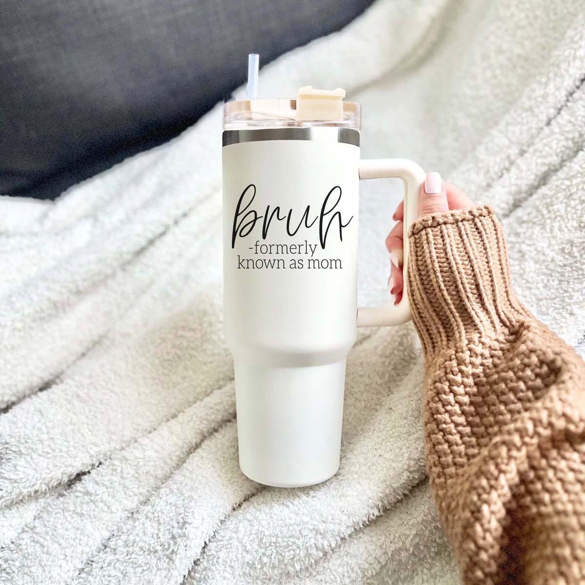 Bruh 40oz tumbler with cream exterior and black graphic design, featuring a handle and a versatile 3-in-1 lid.