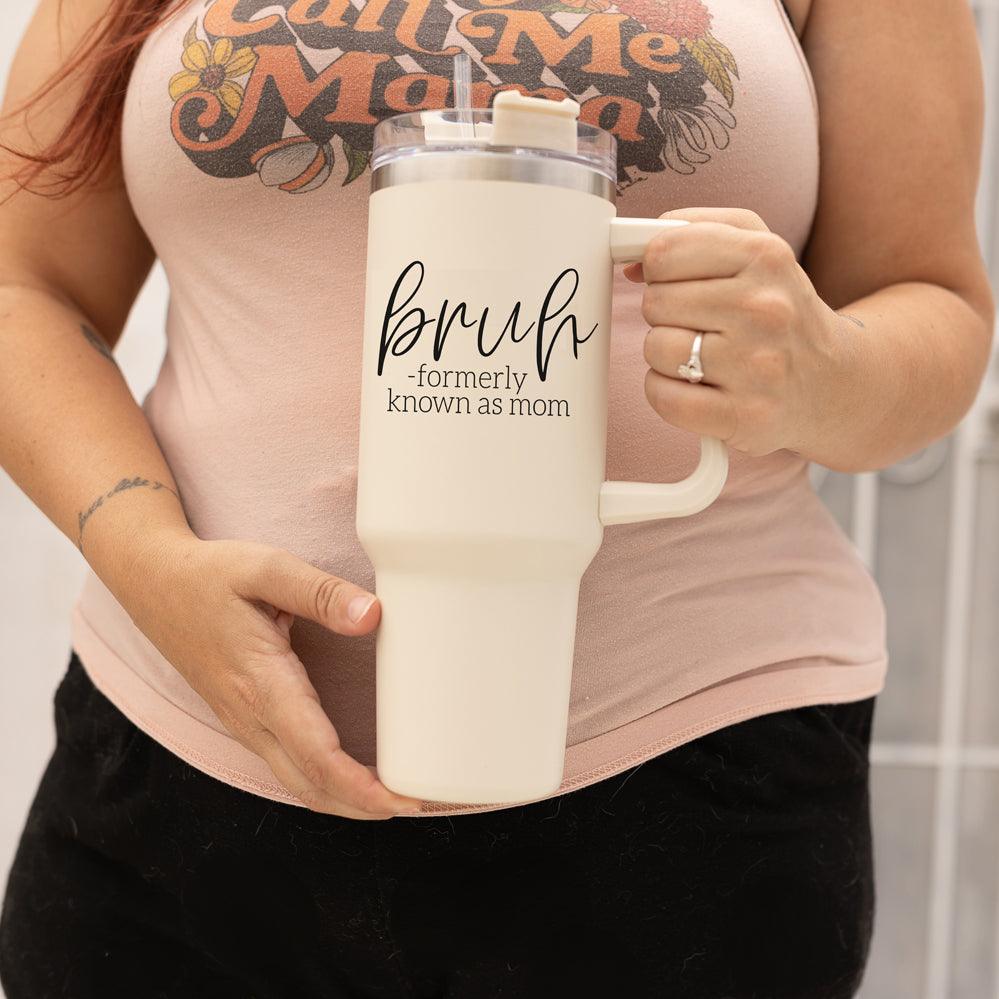 Bruh 40oz tumbler with cream exterior and black graphic design, featuring a handle and a versatile 3-in-1 lid.